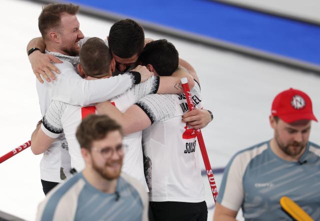 (260221) -- CORTINA D'AMPEZZO, Feb. 21, 2026 (Xinhua) -- Players of Switzerland celebrate victory after winning the curling men's bronze medal game between Norway and Switzerland at the 2026 Milan-Cortina Winter Olympics in Cortina, Italy, Feb. 20, 2026. (Xinhua/Zhang Chenlin)