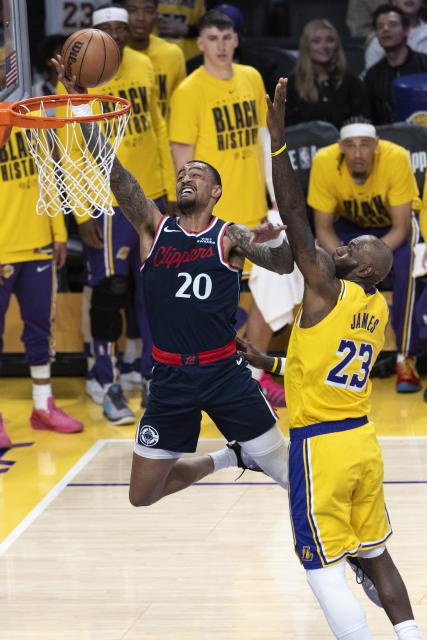(260221) -- LOS ANGELES, Feb. 21, 2026 (Xinhua) -- Los Angeles Clippers' John Collins (L) goes for a layup during the 2025-2026 NBA regular season basketball game between Los Angeles Lakers and Los Angeles Clippers in Los Angeles, the United States, Feb. 20, 2026. (Photo by Ringo Chiu/Xinhua)