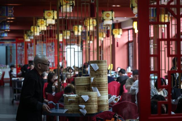 (260221) -- SHENYANG, Feb. 21, 2026 (Xinhua) -- A staff member serves dumplings at Laobian Dumplings, a restaurant chain, in Shenyang, northeast China's Liaoning Province, Feb. 21, 2026. On the fifth day of the Chinese lunar new year, also known as "Powu," a dumpling-eating tradition is observed in many regions across China to ward off evil and disaster, embrace good fortune, and express hopes for the new year. (Xinhua/Pan Yulong)