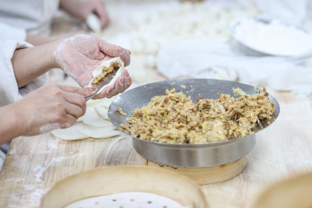 (260221) -- SHENYANG, Feb. 21, 2026 (Xinhua) -- A staff member of Laobian Dumplings makes dumplings in Shenyang, northeast China's Liaoning Province, Feb. 21, 2026. On the fifth day of the Chinese lunar new year, also known as "Powu," a dumpling-eating tradition is observed in many regions across China to ward off evil and disaster, embrace good fortune, and express hopes for the new year. (Xinhua/Pan Yulong)