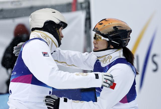 (260221) -- LIVIGNO, Feb. 21, 2026 (Xinhua) -- Xu Mengtao (R) of China hugs her teammate Wang Xindi during the freestyle skiing mixed team aerials final 2 at the Milan-Cortina 2026 Olympic Winter Games in Livigno, Italy, Feb. 21, 2026. (Xinhua/Wang Peng)