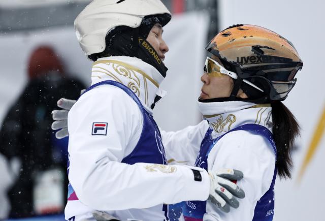 (260221) -- LIVIGNO, Feb. 21, 2026 (Xinhua) -- Xu Mengtao (R) of China hugs her teammate Wang Xindi during the freestyle skiing mixed team aerials final 2 at the Milan-Cortina 2026 Olympic Winter Games in Livigno, Italy, Feb. 21, 2026. (Xinhua/Wang Peng)