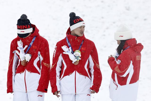 (260221) -- LIVIGNO, Feb. 21, 2026 (Xinhua) -- Bronze Medalists Li Tianma, Wang Xindi and Xu Mengtao (L to R) of China react during the awarding ceremony for freestyle skiing mixed team aerials at the Milan-Cortina 2026 Olympic Winter Games in Livigno, Italy, Feb. 21, 2026. (Xinhua/Wang Peng)