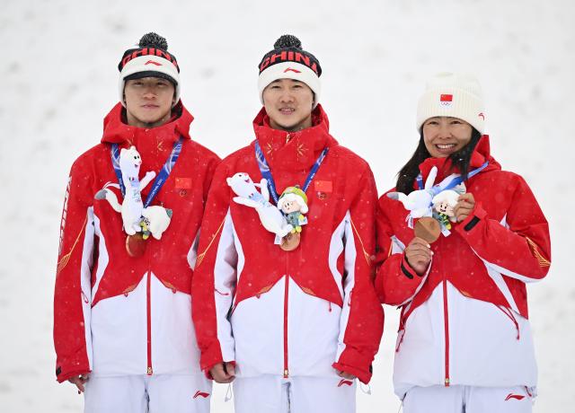 (260221) -- LIVIGNO, Feb. 21, 2026 (Xinhua) -- Bronze Medalists Li Tianma, Wang Xindi and Xu Mengtao (L to R) of China pose during the awarding ceremony for freestyle skiing mixed team aerials at the Milan-Cortina 2026 Olympic Winter Games in Livigno, Italy, Feb. 21, 2026. (Xinhua/Zhang Hongxiang)