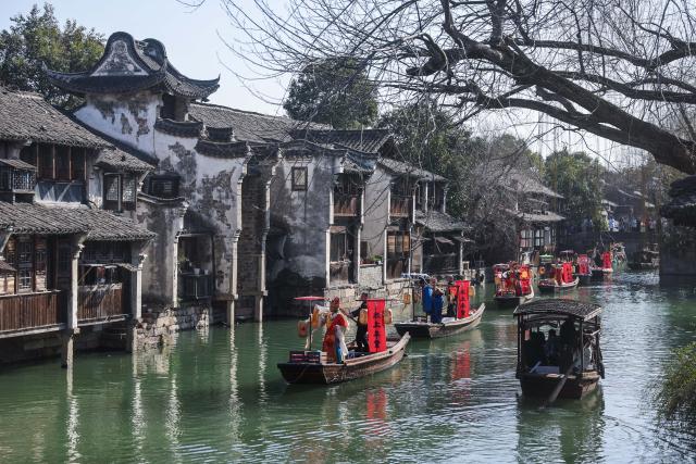 (260221) -- TONGXIANG, Feb. 21, 2026 (Xinhua) -- Artists participate in a parade on water in Wuzhen, Tongxiang City, east China's Zhejiang Province, Feb. 21, 2026. During this Spring Festival holiday, the ancient water town of Wuzhen launched over sixty activities which present the town's rich history and modern vitality reflected in folk customs, drama, science and technology, and culture. (Xinhua/Xu Yu)
