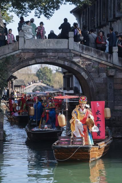 (260221) -- TONGXIANG, Feb. 21, 2026 (Xinhua) -- Artists participate in a parade on water in Wuzhen, Tongxiang City, east China's Zhejiang Province, Feb. 21, 2026. During this Spring Festival holiday, the ancient water town of Wuzhen launched over sixty activities which present the town's rich history and modern vitality reflected in folk customs, drama, science and technology, and culture. (Xinhua/Xu Yu)