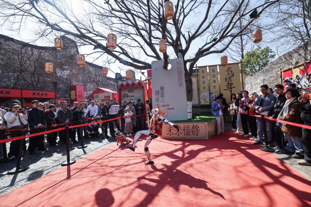 (260221) -- TONGXIANG, Feb. 21, 2026 (Xinhua) -- A robot performs in Wuzhen, Tongxiang City, east China's Zhejiang Province, Feb. 21, 2026. During this Spring Festival holiday, the ancient water town of Wuzhen launched over sixty activities which present the town's rich history and modern vitality reflected in folk customs, drama, science and technology, and culture. (Xinhua/Xu Yu)