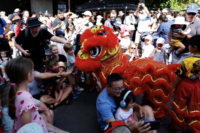 (260221) -- CANBERRA, Feb. 21, 2026 (Xinhua) -- Visitors watch a lion dance performance during an event celebrating the Spring Festival in Canberra, Australia, Feb. 21, 2026. (Photo by Chu Chen/Xinhua)