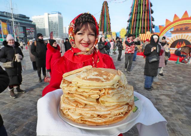 (260221) -- MINSK, Feb. 21, 2026 (Xinhua) -- A staff member presents pancakes during the celebration of Maslenitsa, a religious holiday marking the end of winter and the beginning of spring, in Minsk, Belarus, Feb. 21, 2026. (Photo by Henadz Zhinkov/Xinhua)