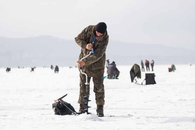 (260221) -- VLADIVOSTOK, Feb. 21, 2026 (Xinhua) -- A man takes part in an ice fishing competition in Vladivostok, Russia, Feb. 21, 2026. (Photo by Andrey Matveenko/Xinhua)