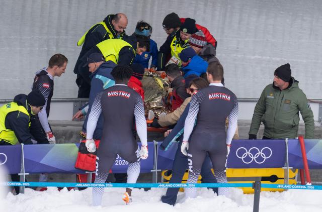 (260221) -- CORTINA D'AMPEZZO, Feb. 21, 2026 (Xinhua) -- Rescue workers and athletes of Austria carry injured athlete Jakob Mandlbauer during the Bobsleigh 4-man heat 2 at the 2026 Milan-Cortina Winter Olympics in Cortina D'Ampezzo, Italy, Feb. 21, 2026. (Xinhua/Fei Maohua)