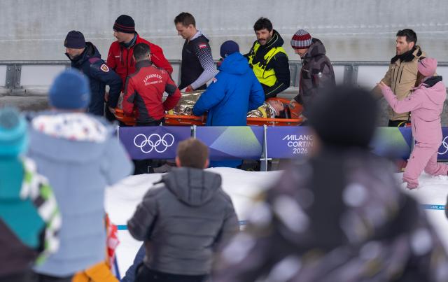 (260221) -- CORTINA D'AMPEZZO, Feb. 21, 2026 (Xinhua) -- Rescue workers and athletes of Austria carry injured athlete Jakob Mandlbauer during the Bobsleigh 4-man heat 2 at the 2026 Milan-Cortina Winter Olympics in Cortina D'Ampezzo, Italy, Feb. 21, 2026. (Xinhua/Fei Maohua)