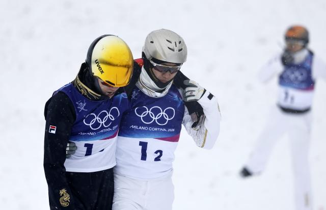 (260221) -- LIVIGNO, Feb. 21, 2026 (Xinhua) -- Wang Xindi (C) of China comforts teammate Li Tianma (L) at the freestyle skiing mixed team aerials final 2 at the Milan-Cortina 2026 Olympic Winter Games in Livigno, Italy, Feb. 21, 2026. (Xinhua/Wang Peng)