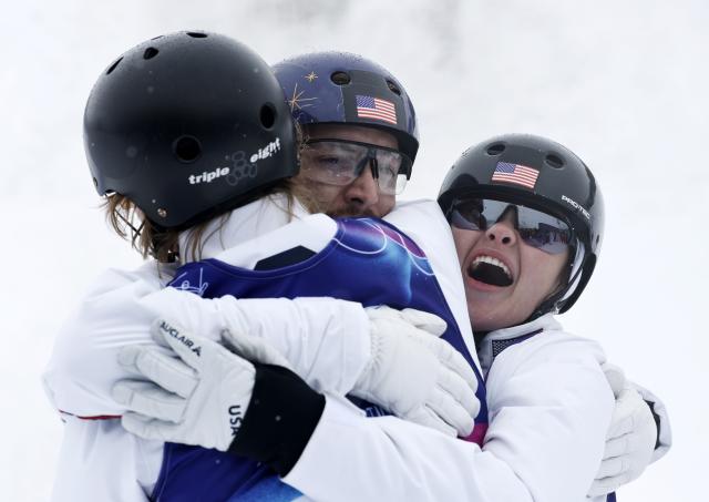 (260221) -- LIVIGNO, Feb. 21, 2026 (Xinhua) -- Christopher Lillis (C), Connor Curran (L) and Kaila Kuhn of the United States celebrate after the freestyle skiing mixed team aerials final 2 at the Milan-Cortina 2026 Olympic Winter Games in Livigno, Italy, Feb. 21, 2026. (Xinhua/Wang Peng)