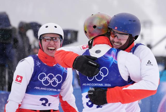 (260221) -- LIVIGNO, Feb. 21, 2026 (Xinhua) -- Noe Roth (R), Pirmin Werner (C) and Lina Kozomara of Switzerland celebrate after the freestyle skiing mixed team aerials final 2 at the Milan-Cortina 2026 Olympic Winter Games in Livigno, Italy, Feb. 21, 2026. (Xinhua/Hu Chao)