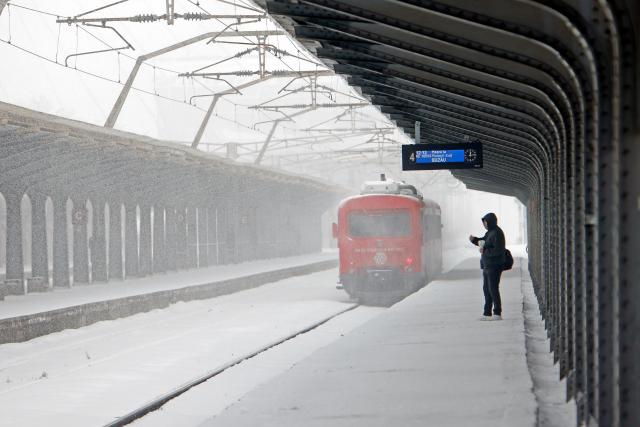 (260221) -- BUCHAREST, Feb. 21, 2026 (Xinhua) -- A man is pictured amid snowfall on a platform at North Railway station in Bucharest, Romania, on Feb. 21, 2026. Heavy snow, strong winds and icy conditions on Saturday again affected roads, maritime ports and power supplies across southern and eastern Romania, according to authorities. (Photo by Cristian Cristel/Xinhua)