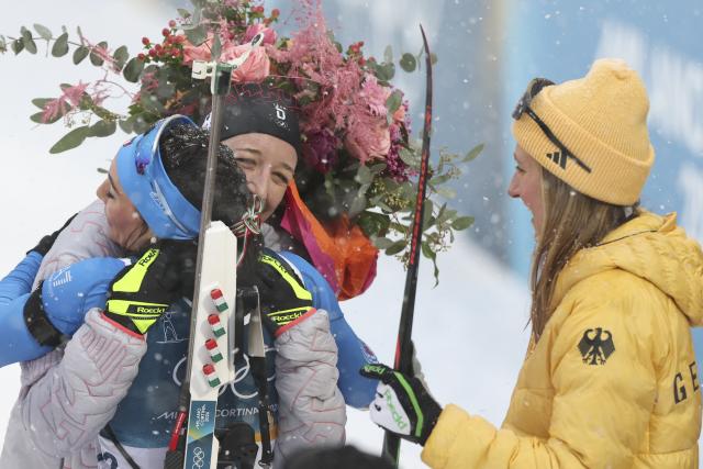 (260221) -- ANTERSELVA, Feb. 21, 2026 (Xinhua) -- Franziska Preuss (L) of Germany hugs Dorothea Wierer of Italy after the biathlon women's 12.5km mass start event at the 2026 Milan-Cortina Winter Olympics in Anterselva, Italy, Feb. 21, 2026. (Xinhua/Zhang Tao)