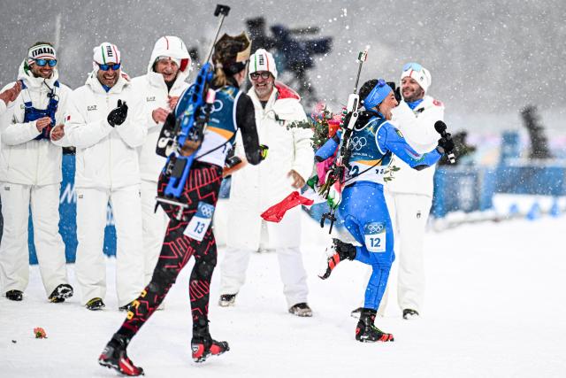 (260221) -- ANTERSELVA, Feb. 21, 2026 (Xinhua) -- Franziska Preuss (L, front) of Germany and Dorothea Wierer of Italy celebrate during a retirement ceremony after the biathlon women's 12.5km mass start event at the 2026 Milan-Cortina Winter Olympics in Anterselva, Italy, Feb. 21, 2026. (Xinhua/Jiang Han)
