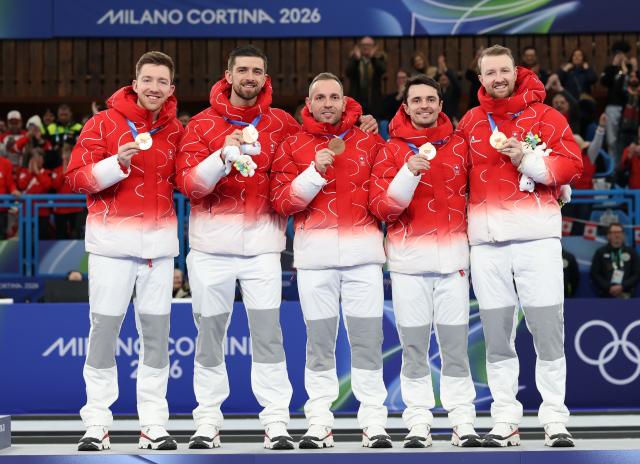 (260222) -- CORTINA D'AMPEZZO, Feb. 22, 2026 (Xinhua) -- Bronze medalists players of Switzerland pose for photos during the awarding ceremony after the curling men's gold medal game between Canada and Britain at the 2026 Milan-Cortina Winter Olympics in Cortina, Italy, Feb. 21, 2026. (Xinhua/Zhang Chenlin)