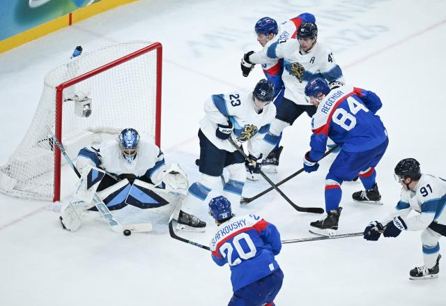 (260222) -- MILAN, Feb. 22, 2026 (Xinhua) -- Juraj Slafkovsky (bottom) of Slovakia shoots during the ice hockey men's bronze medal game between Slovakia and Finland at the Milan-Cortina 2026 Olympic Winter Games in Milan, Italy, Feb. 21, 2026. (Xinhua/Zhang Haofu)