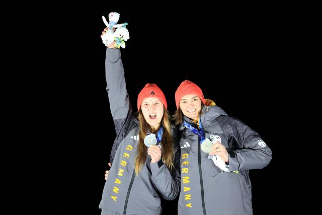 (260222) -- CORTINA D'AMPEZZO, Feb. 22, 2026 (Xinhua) -- Silver medalists Lisa Buckwitz (L)/Neele Schuten of Germany celebrate during the awarding ceremony for the Bobsleigh 2-woman at the 2026 Milan-Cortina Winter Olympics in Cortina, Italy, Feb. 21, 2026. (Xinhua/Ding Xu)