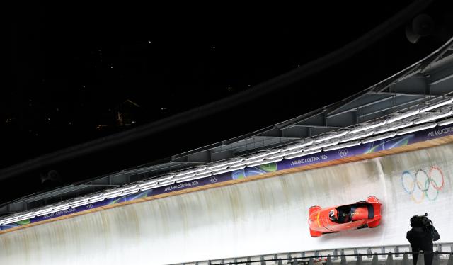 (260222) -- CORTINA D'AMPEZZO, Feb. 22, 2026 (Xinhua) -- Huai Mingming/Wang Xuan of China compete during the Bobsleigh 2-woman heat 3 at the 2026 Milan-Cortina Winter Olympics in Cortina, Italy, Feb. 21, 2026. (Xinhua/Ding Xu)
