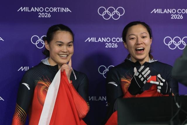 (260222) -- CORTINA D'AMPEZZO, Feb. 22, 2026 (Xinhua) -- Huai Mingming (L)/Wang Xuan of China react after the Bobsleigh 2-woman heat 4 at the 2026 Milan-Cortina Winter Olympics in Cortina, Italy, Feb. 21, 2026. (Xinhua/Ding Xu)