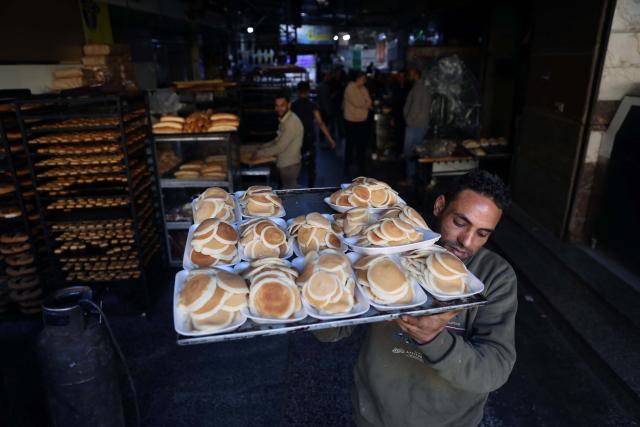 (260222) -- CAIRO, Feb. 22, 2026 (Xinhua) -- A baker carries traditional sweets known as "Qatayef" for sale during the holy month of Ramadan in Cairo, Egypt, on Feb. 21, 2026. Egyptians eat traditional sweets during Ramadan to break their fast. (Xinhua/Ahmed Gomaa)