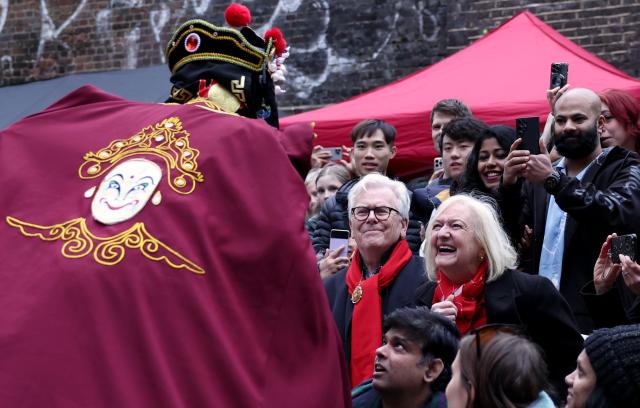 (260222) -- LONDON, Feb. 22, 2026 (Xinhua) -- An artist interacts with spectators as he performs Sichuan Opera face-changing during a Chinese New Year celebration at Camden Market in London, Britain, Feb. 21, 2026. (Xinhua/Li Ying)