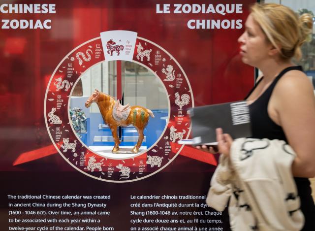 (260222) -- TORONTO, Feb. 22, 2026 (Xinhua) -- A visitor walks past an exhibit of the Year of the Horse from the Chinese Zodiac Case exhibition at the Royal Ontario Museum in Toronto, Canada, on Feb. 21, 2026. Featuring a rich collection of horse-themed objects and cultural artifacts, this annual Chinese zodiac exhibition opened here on Feb. 10 and will last until Jan. 31, 2027. (Photo by Zou Zheng/Xinhua)