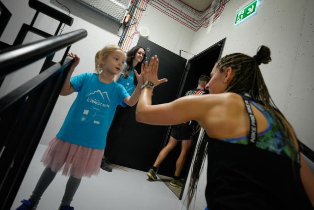 (260222) -- WARSAW, Feb. 22, 2026 (Xinhua) -- A participant (R) high-fives a child volunteer in the staircase inside the Skyliner building during the Skyliner Everest Run 2026 in Warsaw, Poland on Feb. 21, 2026. The event requires competitors to ascend the 42-floor staircase 55 times within 24 hours, reaching a cumulative height equivalent to the world's highest peak, Mount Qomolangma. (Photo by Jaap Arriens/Xinhua)