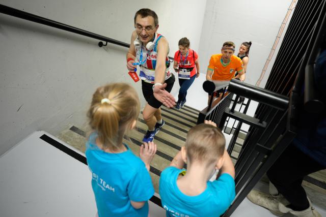 (260222) -- WARSAW, Feb. 22, 2026 (Xinhua) -- A participant high-fives a child volunteer in the staircase inside the Skyliner building during the Skyliner Everest Run 2026 in Warsaw, Poland on Feb. 21, 2026. The event requires competitors to ascend the 42-floor staircase 55 times within 24 hours, reaching a cumulative height equivalent to the world's highest peak, Mount Qomolangma. (Photo by Jaap Arriens/Xinhua)