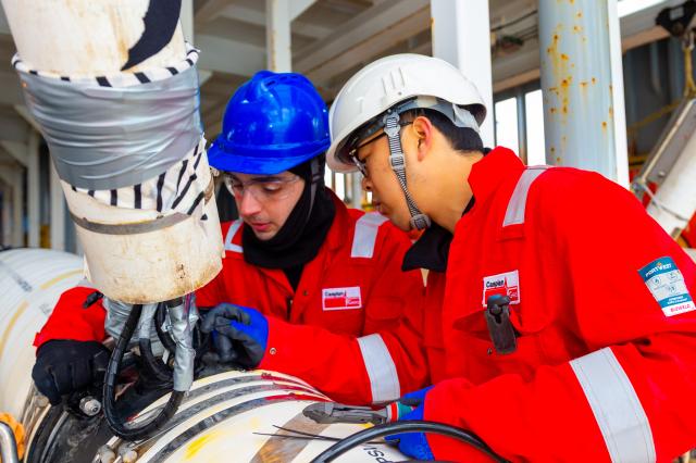 (260222) -- BAKU, Feb. 22, 2026 (Xinhua) -- A Chinese technician (R) instructs an Azerbaijani technician on a source vessel at the Baku Shipyard in Baku, Azerbaijan, Feb. 10, 2026. TO GO WITH "Feature: 'Caspian' Spring Festival for Chinese oil explorers supporting Azerbaijan's energy exploration" (Xinhua/Chen Junfeng)