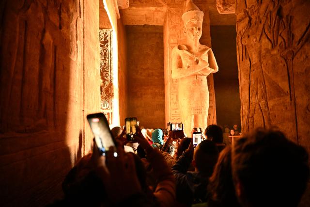(260222) -- ASWAN, Feb. 22, 2026 (Xinhua) -- Tourists take photos at the Great Temple of Abu Simbel during the Sun Festival in Aswan, Egypt, Feb. 22, 2026. During the Sun Festival, which falls on Feb. 22 and Oct. 22 every year, rays of the morning sun would reach the innermost shrine of the Great Temple of Abu Simbel and illuminate the inside sculptures. (Xinhua/Xin Mengchen)