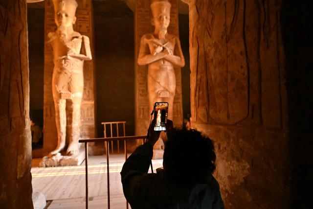 (260222) -- ASWAN, Feb. 22, 2026 (Xinhua) -- A tourist takes photos at the Great Temple of Abu Simbel during the Sun Festival in Aswan, Egypt, Feb. 22, 2026. During the Sun Festival, which falls on Feb. 22 and Oct. 22 every year, rays of the morning sun would reach the innermost shrine of the Great Temple of Abu Simbel and illuminate the inside sculptures. (Xinhua/Xin Mengchen)