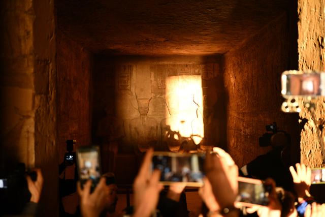 (260222) -- ASWAN, Feb. 22, 2026 (Xinhua) -- Tourists take photos at the Great Temple of Abu Simbel during the Sun Festival in Aswan, Egypt, Feb. 22, 2026. During the Sun Festival, which falls on Feb. 22 and Oct. 22 every year, rays of the morning sun would reach the innermost shrine of the Great Temple of Abu Simbel and illuminate the inside sculptures. (Xinhua/Xin Mengchen)