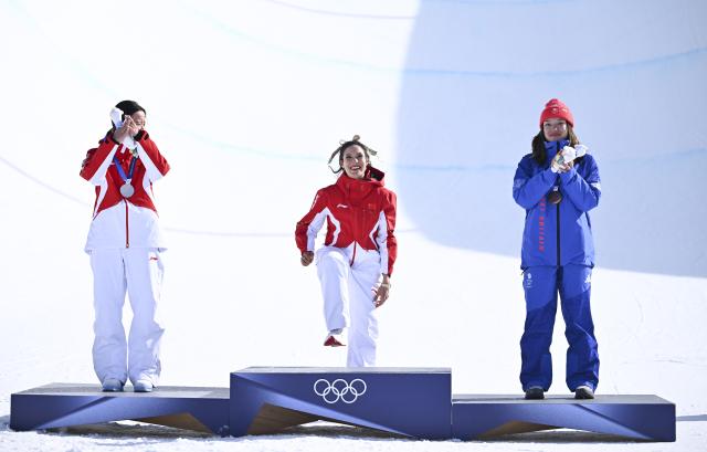 (260222) -- LIVIGNO, Feb. 22, 2026 (Xinhua) -- Gold medalist Gu Ailing (C) of China steps onto the podium during the awarding ceremony for freestyle skiing women's freeski halfpipe at the Milan-Cortina 2026 Olympic Winter Games in Livigno, Italy, Feb. 22, 2026. (Xinhua/Zhang Hongxiang)