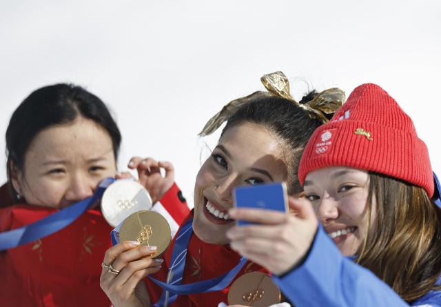 (260222) -- LIVIGNO, Feb. 22, 2026 (Xinhua) -- Silver medalist Li Fanghui (L) of China, gold medalist Gu Ailing of China (C) and bronze medalist Zoe Atkin of Britain take selfies during the awarding ceremony for freestyle skiing women's freeski halfpipe at the Milan-Cortina 2026 Olympic Winter Games in Livigno, Italy, Feb. 22, 2026. (Xinhua/Wang Peng)