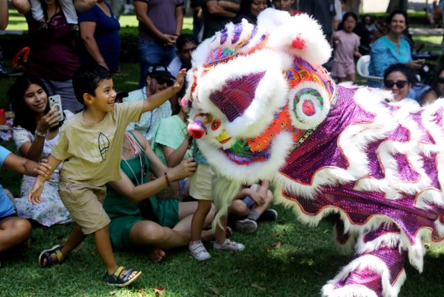 (260222) -- LIMA, Feb. 22, 2026 (Xinhua) -- A boy interacts with a lion dance performer in Lima, Peru, Feb. 21, 2026. Various activities were held by the Confucius Institute at Ricardo Palma University in Lima to celebrate the Chinese New Year on Saturday. (Photo by Mariana Bazo/Xinhua)