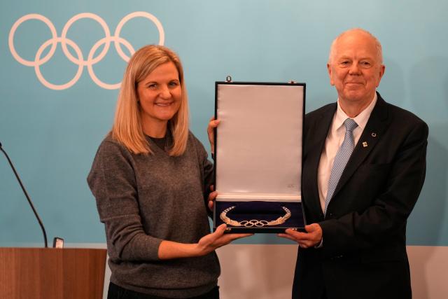 (260222) -- MILAN, Feb. 22, 2026 (Xinhua) -- IOC President Kirsty Coventry (L) presents an award to Olle Dahlin, President of the International Biathlon Union, during an IOC session at the Milan-Cortina 2026 Olympic Winter Games in Milan, Italy, Feb. 22, 2026. (Luca Bruno/Pool via Xinhua)