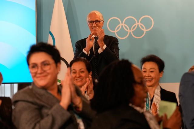 (260222) -- MILAN, Feb. 22, 2026 (Xinhua) -- Giovanni Malago, president of the Milan-Cortina 2026 Organizing Committee (rear), applauds during an IOC session at the Milan-Cortina 2026 Olympic Winter Games in Milan, Italy, Feb. 22, 2026. (Luca Bruno/Pool via Xinhua)