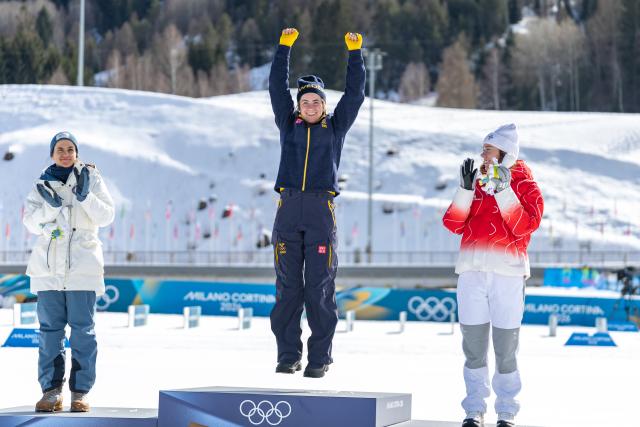 (260222) -- TESERO, Feb. 22, 2026 (Xinhua) -- Gold medalist Ebba Andersson (C) of Sweden jumps onto the podium after the cross-country skiing women's 50km mass start classic match at the Milan-Cortina 2026 Olympic Winter Games in Tesero, Italy, Feb. 22, 2026. (Xinhua/Huang Wei)