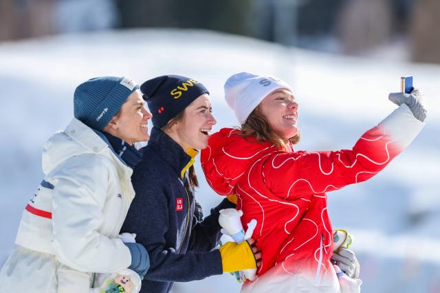 (260222) -- TESERO, Feb. 22, 2026 (Xinhua) -- Gold medalist Ebba Andersson (C) of Sweden, silver medalist Heidi Weng (L) of Norway and bronze medalist Nadja Kaelin of Switzerland take selfies on the podium after the cross-country skiing women's 50km mass start classic match at the Milan-Cortina 2026 Olympic Winter Games in Tesero, Italy, Feb. 22, 2026. (Xinhua/Huang Wei)