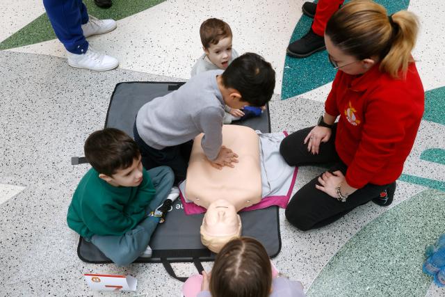 (260222) -- BUCHAREST, Feb. 22, 2026 (Xinhua) -- A child exercises resuscitation maneuvers on a medical mannequin under the supervision of a paramedic (R) during the 5th edition of Resuscitation Marathon at a mall in Bucharest, Romania, Feb. 21, 2026. (Photo by Cristian Cristel/Xinhua)