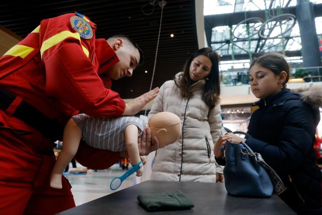 (260222) -- BUCHAREST, Feb. 22, 2026 (Xinhua) -- A paramedic (L) explains resuscitation maneuvers on a medical mannequin during the 5th edition of Resuscitation Marathon at a mall in Bucharest, Romania, Feb. 21, 2026. (Photo by Cristian Cristel/Xinhua)