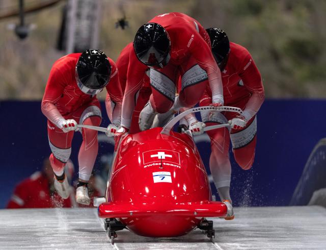 (260222) -- CORTINA D'AMPEZZO, Feb. 22, 2026 (Xinhua) -- Michael Vogt/Andreas Haas/Amadou David Ndiaye/Mario Aeberhard of Switzerland compete during the Bobsleigh 4-man heat 3 at the 2026 Milan-Cortina Winter Olympics in Cortina D'Ampezzo, Italy, Feb. 22, 2026. (Xinhua/Fei Maohua)