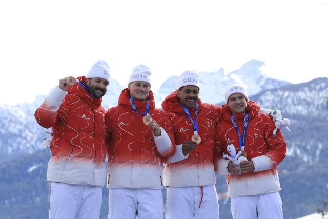 (260222) -- CORTINA D'AMPEZZO, Feb. 22, 2026 (Xinhua) -- Bronze medalists Michael Vogt/Andreas Haas/Amadou David Ndiaye/Mario Aeberhard of Switzerland (L to R) pose during the awarding ceremony for Bobsleigh 4-man at the 2026 Milan-Cortina Winter Olympics in Cortina D'Ampezzo, Italy, Feb. 22, 2026. (Xinhua/Ding Xu)
