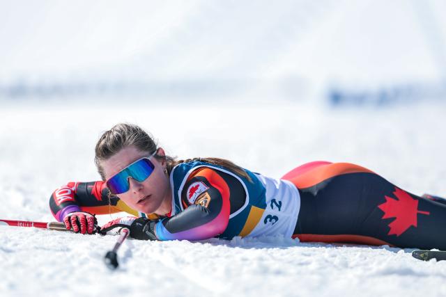 (260222) -- TESERO, Feb. 22, 2026 (Xinhua) -- Jasmine Drolet of Canada lies on the snow after crossing the finish line during the cross-country skiing women's 50km mass start classic match at the Milan-Cortina 2026 Olympic Winter Games in Tesero, Italy, Feb. 22, 2026. (Xinhua/Huang Wei)