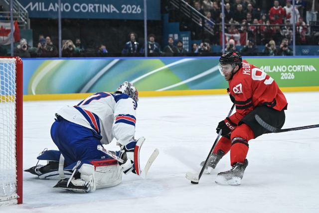(260222) -- MILAN, Feb. 22, 2026 (Xinhua) -- Connor Mcdavid (R) of Canada shoots during the ice hockey men's gold medal game between Canada and the United States at the Milan-Cortina 2026 Olympic Winter Games in Milan, Italy, Feb. 22, 2026. (Xinhua/Zhang Haofu)