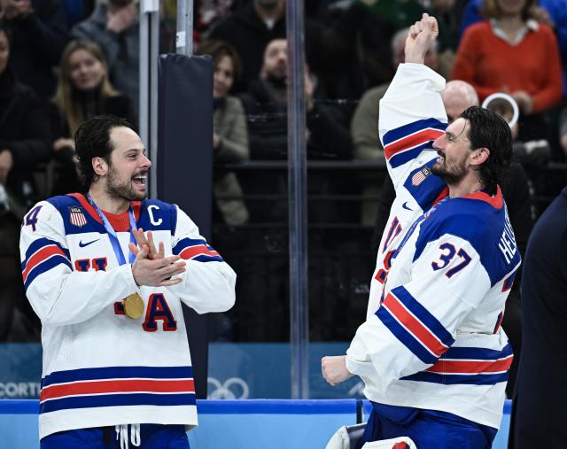 (260222) -- MILAN, Feb. 22, 2026 (Xinhua) -- Goalkeeper Connor Hellebuyck (R) of the United States celebrates after the ice hockey men's gold medal game between Canada and the United States at the Milan-Cortina 2026 Olympic Winter Games in Milan, Italy, Feb. 22, 2026. (Xinhua/Zhang Haofu)